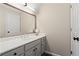 Well-lit powder room featuring grey vanity and an expansive mirror, designed with functionality and style at 410 Hickory Fairway Ct, Woodstock, GA 30188