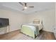 Serene bedroom with a comfy bed, tray ceiling, wood floors, and a side table at 410 Hickory Fairway Ct, Woodstock, GA 30188