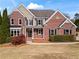 Classic brick home with symmetrical design, manicured shrubs, and inviting front entrance at 410 Hickory Fairway Ct, Woodstock, GA 30188