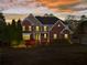 Elegant brick home at dusk, showcasing its exterior lighting and curb appeal at 410 Hickory Fairway Ct, Woodstock, GA 30188