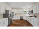 Well-lit kitchen with stainless steel appliances, white cabinetry, and sleek countertops at 410 Hickory Fairway Ct, Woodstock, GA 30188