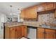 Convenient kitchenette area with wood cabinets, granite countertops, and a stainless steel dishwasher at 410 Hickory Fairway Ct, Woodstock, GA 30188