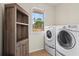 Bright laundry room with modern washer and dryer, built in storage, and natural light at 410 Hickory Fairway Ct, Woodstock, GA 30188