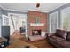 Cozy living room featuring a brick fireplace, hardwood floors, and a comfortable leather sofa at 410 Hickory Fairway Ct, Woodstock, GA 30188