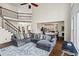 Open-concept living room adjacent to the kitchen has hardwood floors and staircase to the second level at 410 Hickory Fairway Ct, Woodstock, GA 30188