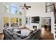 Inviting living room boasts soaring windows, cozy fireplace, and open access to a private deck at 410 Hickory Fairway Ct, Woodstock, GA 30188