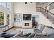 Comfortable living room with fireplace, built-in shelves, hardwood floors, and staircase to the second level at 410 Hickory Fairway Ct, Woodstock, GA 30188