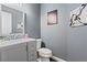 Stylish powder room featuring a gray vanity, modern fixtures, and elegant wall art at 410 Hickory Fairway Ct, Woodstock, GA 30188