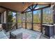 Cozy screened porch with wicker sofa and a view of the landscaped backyard at 410 Hickory Fairway Ct, Woodstock, GA 30188