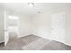 A simple bedroom with gray carpet, white walls, and natural light from a window at 4798 Red Lion Pl, Lawrenceville, GA 30044