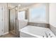 Bright bathroom featuring a garden tub and a walk-in shower with glass door at 4798 Red Lion Pl, Lawrenceville, GA 30044