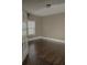 Simple bedroom featuring hardwood floors, white trim, and ample natural light at 505 Mirror Lake Pkwy, Villa Rica, GA 30180