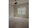 Bright, carpeted bedroom with window and ceiling fan at 505 Mirror Lake Pkwy, Villa Rica, GA 30180