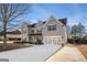 Charming two-story home featuring a neutral color palette, shuttered windows and a wide driveway and two-car garage at 505 Mirror Lake Pkwy, Villa Rica, GA 30180