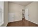 Well-lit empty bedroom with hardwood floors, closet, and a view to the entry way at 559 Myrle Trace Ln, Suwanee, GA 30024