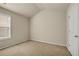 A neutrally painted and carpeted bedroom with a window and an entry door, offering a cozy atmosphere at 559 Myrle Trace Ln, Suwanee, GA 30024