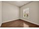 Bright, empty bedroom with hardwood floors and a large window at 559 Myrle Trace Ln, Suwanee, GA 30024