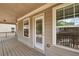 A covered porch with natural light shining on the wooden flooring, railings, and exterior door at 559 Myrle Trace Ln, Suwanee, GA 30024