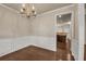 Dining room with hardwood floors, wainscoting, chandelier and open view to the kitchen at 559 Myrle Trace Ln, Suwanee, GA 30024