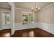 Bright dining room with hardwood floors, wainscoting, window view and access to entryway at 559 Myrle Trace Ln, Suwanee, GA 30024