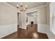 Elegant dining room with chandelier, wainscoting and hardwood floors, with view to living room at 559 Myrle Trace Ln, Suwanee, GA 30024