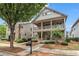 Welcoming two-story home showcasing a charming front porch and a balcony, surrounded by a beautifully landscaped garden at 559 Myrle Trace Ln, Suwanee, GA 30024