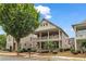 Charming two-story home with a inviting front porch and a balcony, complemented by professionally landscaped greenery at 559 Myrle Trace Ln, Suwanee, GA 30024