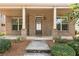 Charming brick home with a covered front porch and lush landscaping at 559 Myrle Trace Ln, Suwanee, GA 30024