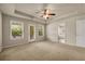 Spacious main bedroom features tray ceilings, fan, and access to bath and exterior balcony at 559 Myrle Trace Ln, Suwanee, GA 30024