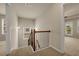 Hallway staircase with brown railings and neutral-toned walls and carpeting at 559 Myrle Trace Ln, Suwanee, GA 30024