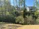 View of backyard showing a wooded area with mature trees and a glimpse of surrounding homes at 108 Deer Xing, Temple, GA 30179
