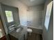 Bright bathroom with a single sink, a bathtub-shower combo, and a large window at 108 Deer Xing, Temple, GA 30179