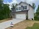Charming two-story home with a brick and siding exterior, a two-car garage, and a large front yard at 108 Deer Xing, Temple, GA 30179