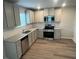 Well-equipped kitchen featuring stainless steel appliances, granite countertops, and gray cabinets for a modern touch at 108 Deer Xing, Temple, GA 30179