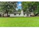 View of the home's backyard featuring green grass, mature trees, and a patio at 2508 Wagon Trce, Duluth, GA 30096