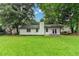 View of the home's backyard featuring green grass, mature trees, and a patio at 2508 Wagon Trce, Duluth, GA 30096