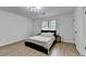 Bright bedroom featuring wood-look floors, a large window, and a modern light fixture at 2508 Wagon Trce, Duluth, GA 30096
