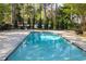 Sparkling outdoor pool with adjacent playground, surrounded by mature trees and lush greenery at 260 Manning Sw Rd # 76, Marietta, GA 30064