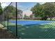 Community tennis court surrounded by secure fencing and lush green trees for a serene playing experience at 260 Manning Sw Rd # 76, Marietta, GA 30064
