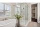 Modern bathroom featuring a glass shower, a soaking tub, and a view from the window at 3332 Old Concord Se Rd, Smyrna, GA 30082