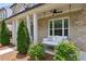 Inviting front porch featuring a cozy porch swing, brick facade, and manicured landscaping at 3332 Old Concord Se Rd, Smyrna, GA 30082