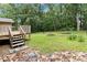 View of backyard and deck with lush green grass, landscaping and a wooded view at 574 Horseshoe Sw Cir, Lilburn, GA 30047