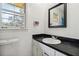 Bathroom featuring a sink with black countertop, and window view at 574 Horseshoe Sw Cir, Lilburn, GA 30047