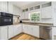 Well-lit kitchen with white cabinetry, granite countertops, stainless steel appliances, and hardwood flooring at 574 Horseshoe Sw Cir, Lilburn, GA 30047