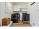 Bright laundry room featuring modern washer, dryer, cabinets, and wood-look floors at 574 Horseshoe Sw Cir, Lilburn, GA 30047