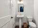 Cozy powder room features a pedestal sink, a framed mirror, and modern toilet at 988 Viney Nw Way, Atlanta, GA 30318