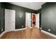 Spacious bedroom with dark green paint, wood floors, and access to other rooms through white doors at 988 Viney Nw Way, Atlanta, GA 30318