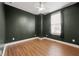 Well-lit bedroom features dark green paint, wood floors, and a large window for natural light at 988 Viney Nw Way, Atlanta, GA 30318