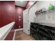 Modern laundry room featuring black washer and dryer, storage shelf, and striking red accent wall at 988 Viney Nw Way, Atlanta, GA 30318