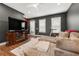 Cozy living room features a plush sectional sofa, a large TV, and views of the outdoor landscape at 988 Viney Nw Way, Atlanta, GA 30318
